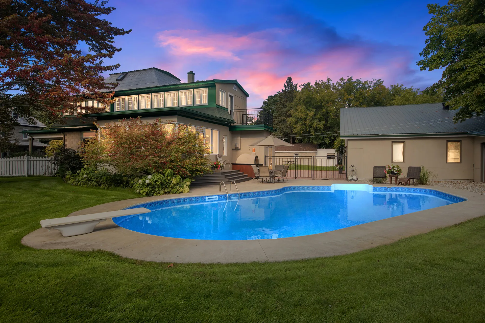 Backyard pool with grass and trees behind house California real estate.