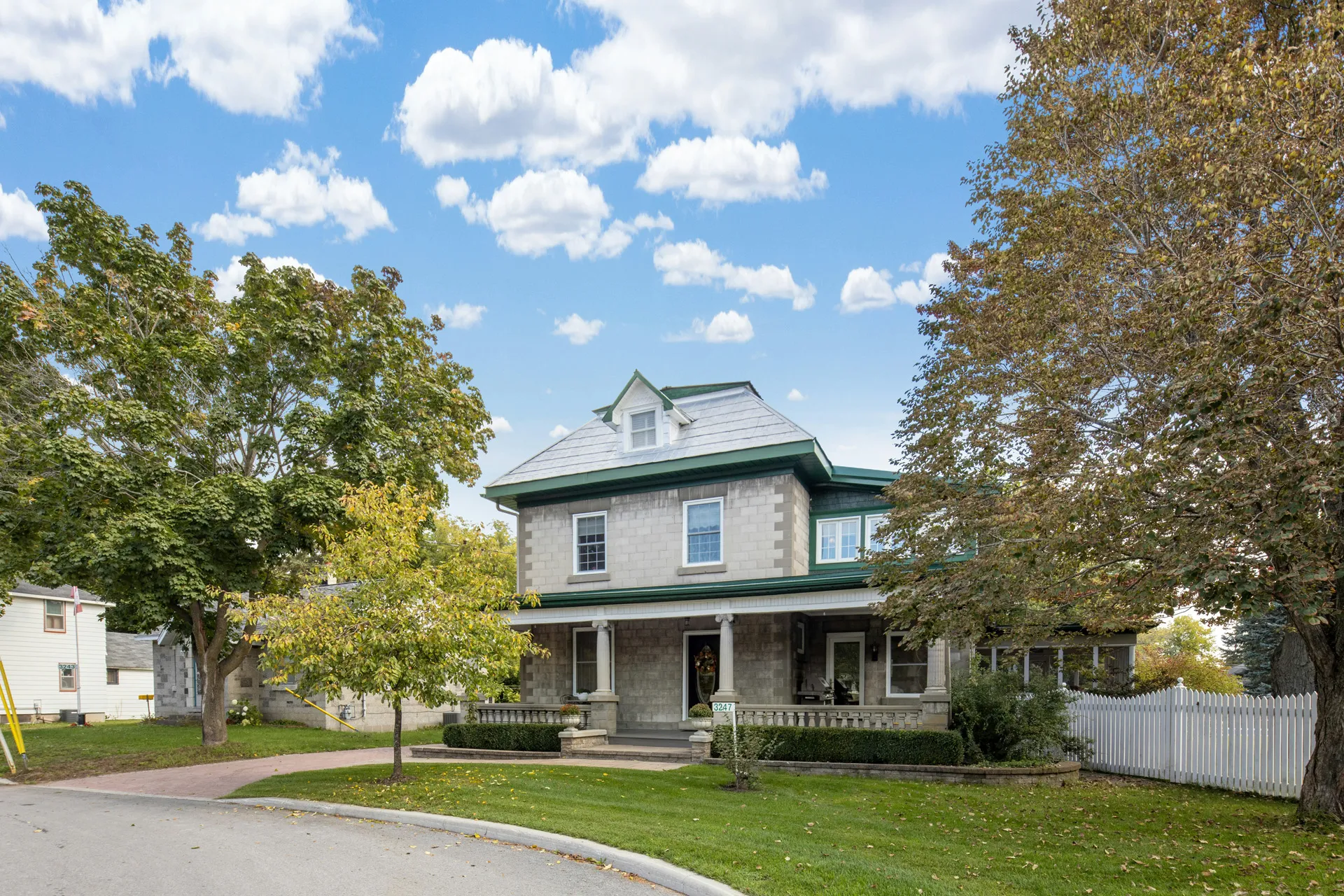 Two story house California real estate with porch, trees, and lawn.