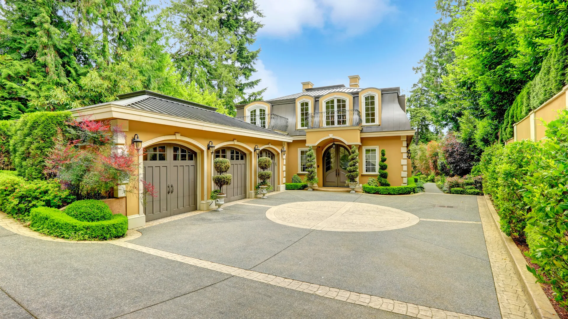 House California real estate with yellow walls, arched windows, double garage, and driveway.